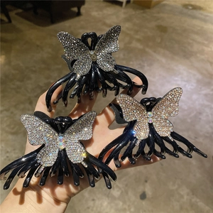 Détail de trois pinces à cheveux en résine avec motifs de papillons strass scintillants