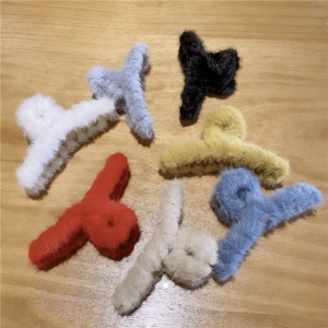 Detailed overhead view of plush faux fur hair claw clips in seven various colors