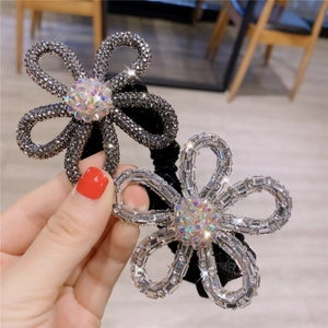 Detailed shot of glittering crystal flower hair ties with high elasticity black bands