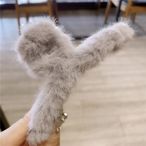 Detail of light grey faux fur hair claw clip with sparkling rhinestone decorations