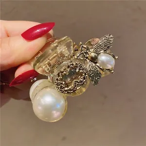 Detailopname van de barokke haarklem met parels, metalen bij en vintage edelsteen