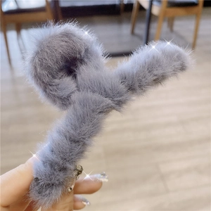 Close-up of soft gray faux fur hair claw clip for elegant winter hairstyling