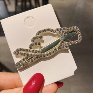 Détail macro d'une pince à cheveux dorée ornée de strass brillants et d'un nœud