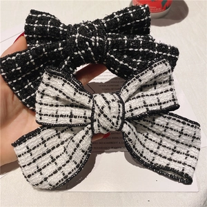 Elegant tweed bow hair clips in classic black and white plaid pattern for women
