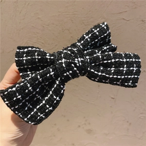 Classic black and white tweed bow hair clip with textured fabric and vintage design