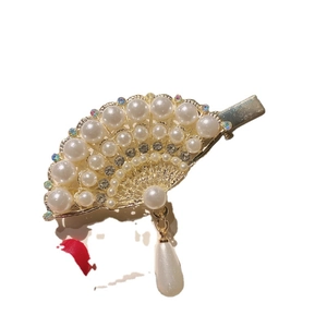 Elegant fan-shaped hair clip with pearls and rhinestones on a gold metal crocodile clip