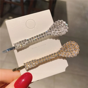 Détail de barrettes à strass étincelants en or et argent présentées sur une carte