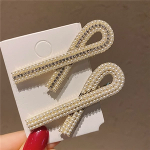 Gros plan de barrettes élégantes en alliage doré avec perles et strass brillants de luxe