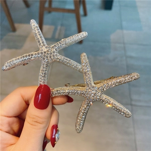 Détail des barrettes en forme d'étoile de mer avec strass brillants et pince en métal