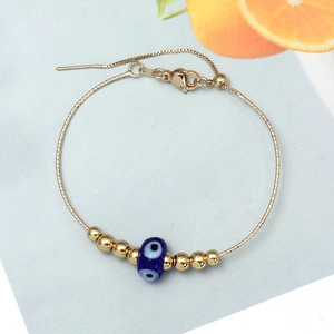 Detailed view of the evil eye bracelet featuring gold beads and adjustable chain link