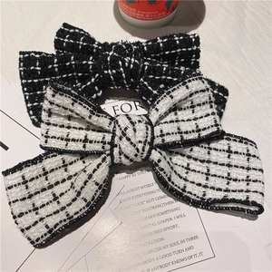 Detailed close-up of vintage black and white tweed bow hair clips in chic French style