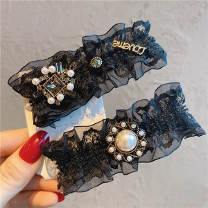 Detail of vintage black lace hair clips with pearls, rhinestones and metal Loveme tag
