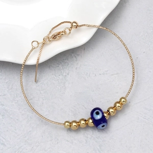 Adjustable golden box chain evil eye bracelet with blue beads and lucky metal sphere accents