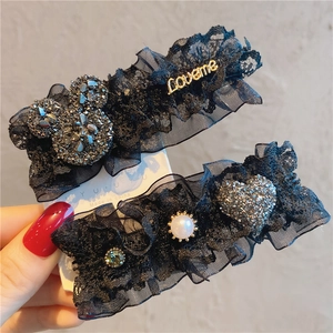 Detail of black lace hair clips featuring Mickey rhinestones, pearls and Loveme metal letters