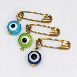 Detalle de tres imperdibles de ojo turco en color azul cielo, verde lima y azul oscuro