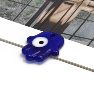 Detailopname van blauwe glazen Hamsa Hand hanger tegen het boze oog met oogje