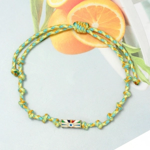 Detail of hand-woven cord evil eye bracelet with yellow and blue threads and enamel charm