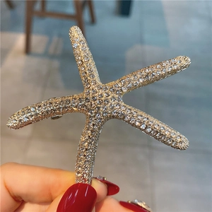 Gros plan détaillé d'une pince à cheveux étoile de mer avec strass étincelants sur alliage doré