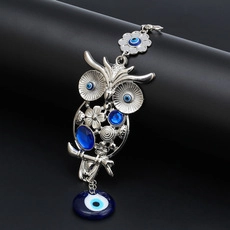 Detail of owl evil eye keychain featuring silver metal craftsmanship and blue Nazar beads