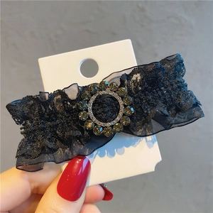 Detail of vintage black lace hair clip with sparkling grey rhinestones on a white card