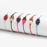 Detail showing colorful braided Hamsa Hand bracelets with enamel evil eye pendants