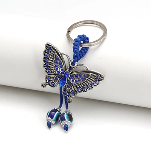 Close-up of butterfly evil eye keychain with blue rhinestones and braided rope details