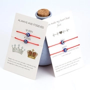 Detail of red braided Evil Eye bracelets for couples with King and Queen display card