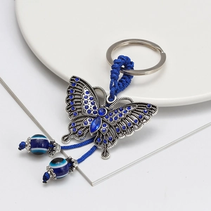 Detail of butterfly keychain featuring blue rhinestones and evil eye protective beads