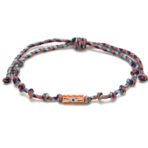 Close-up of a colorful woven rope bracelet featuring an orange Evil Eye gold charm