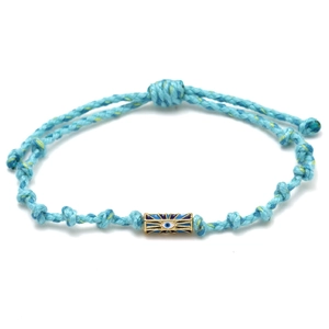 Detail of hand-woven cord bracelet with a golden evil eye charm and blue accents