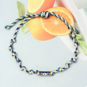 Macro detail of hand-woven Evil Eye bracelet with hexagonal beads and colorful braided rope