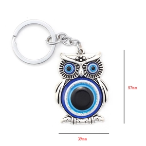 Detailed size view of silver metal owl keychain with evil eye charm, 57mm by 39mm