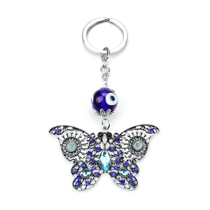 Macro detail of butterfly keychain with blue evil eye bead and sparkling rhinestones