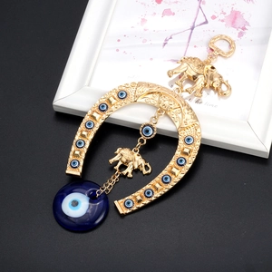 Blue Evil Eye wall hanging ornament with golden horseshoe and elephant accents