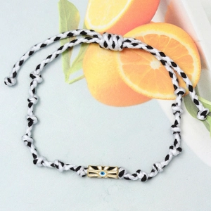 Detail of hand-woven Evil Eye bracelet with golden hexagonal charm and adjustable cord