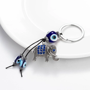 Lucky elephant keychain with blue evil eye beads and silver alloy charm on a white plate