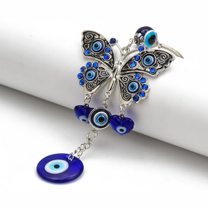 Macro detail of silver butterfly keychain with blue evil eye heart pendants and charms
