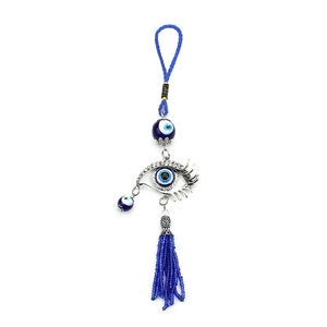 Detail of Turkish Evil Eye amulet with blue glass bead and elegant beaded tassels