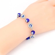 Detail shot of Evil Eye bracelet with blue glass beads and silver rhinestone rings on wrist