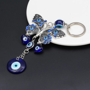 Detail of butterfly keychain with blue evil eye charms on black and white background