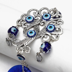 Macro shot of the Tree of Life evil eye charm featuring blue glass beads and silver alloy