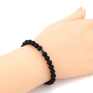 Matte black volcanic stone bracelet for men featuring a blue evil eye bead detail