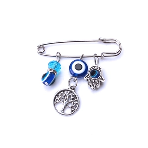 Dettaglio spilla argento con ciondoli occhio blu e pendente dell'Albero della Vita