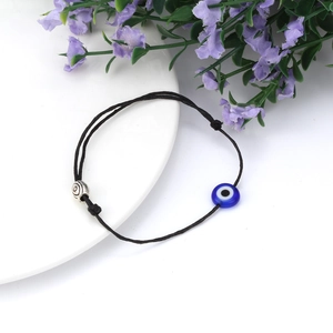Detail van zwarte gevlochten armband met blauwe evil eye kraal en zilveren metalen kraal