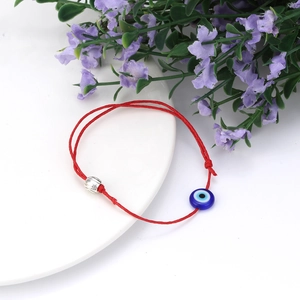Detail van rood gevlochten Evil Eye armband met zilveren kraal en verstelbare knoop