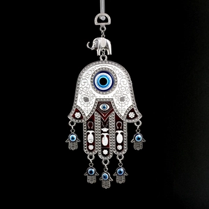 Hamsa Hand and Evil Eye hanging ornament with elephant charm on black background