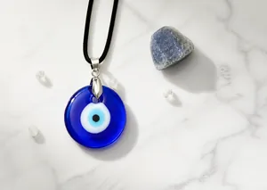 Macro detail of deep blue glass Evil Eye pendant with black waxed rope necklace cord