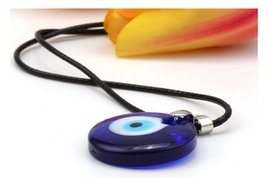 Detail of blue evil eye glass pendant on black cord necklace with floral accent