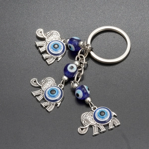Porte-clés éléphant avec œil maléfique bleu, pendentifs en argent et perles bleues sur fond gris