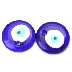 Macro view of two blue glass evil eye beads with drill holes for DIY jewelry making